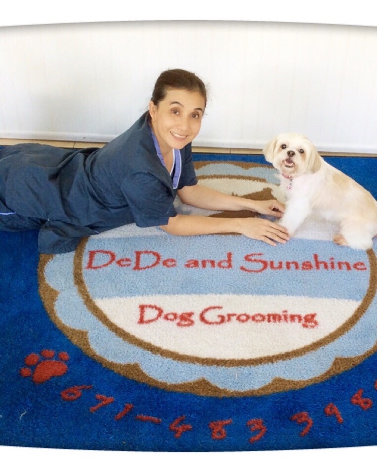DeDe smiling with a groomed pup on the DeDe and Sunshine branded rug